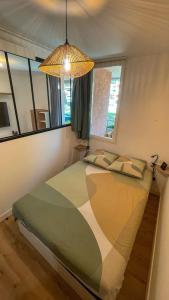 1 dormitorio con 1 cama grande, lámpara y ventanas en T2 30m2 proche plage, rénové et équipé, en Bormes-les-Mimosas