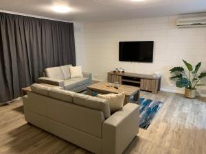 - un salon avec un canapé et une télévision dans l'établissement Harbour View 49 Urch Street Unit 4, à Geraldton