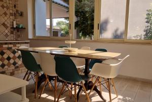 a dining room table with green chairs and a table at Villa Ada Casa Vacanze in Torre Specchia Ruggeri