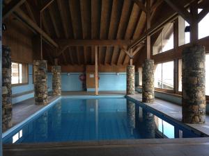 a large indoor swimming pool with a wooden ceiling at Appartement Villard-sur-Doron, 5 pièces, 10 personnes - FR-1-594-226 in Villard-sur-Doron