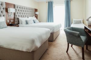a hotel room with two beds and a desk and a chair at The Wyatt Hotel in Westport
