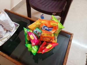 a pile of chips and other snacks on a glass table at Bay Inn in Puri