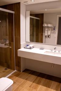 a bathroom with a sink and a toilet and a mirror at Hotel Senac Ilha do Boi in Vitória