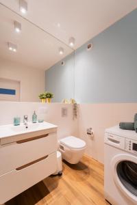 a bathroom with a toilet and a washing machine at Nice Apartment - Near Sky Tower - Private Parking in Wrocław