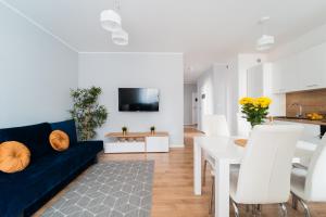 a living room with a blue couch and a table at Nice Apartment - Near Sky Tower - Private Parking in Wrocław