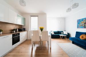 una cucina e un soggiorno con tavolo e sedie di Nice Apartment - Near Sky Tower - Private Parking a Breslavia