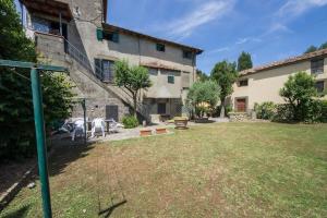 un cortile con un edificio e un tavolo con sedie di casastagi a Castelfranco di Sopra