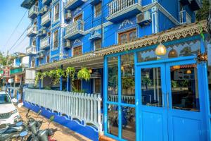 Casa Eternal Boutique Hotel - Calangute في كالانغيُت: مبنى ازرق امامه سياج ابيض