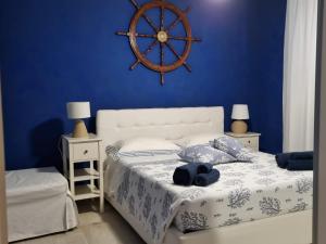 a bedroom with a white bed with a blue wall at Villa Ada Casa Vacanze in Torre Specchia Ruggeri