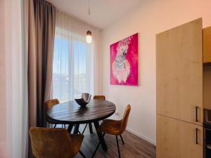 a dining room with a table and chairs and a painting at TwoParrots app. with garage, balkony, citycenter in Žilina