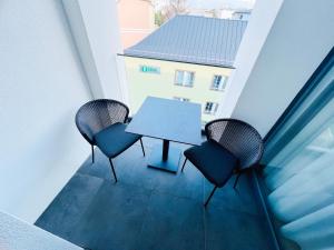 a table and chairs on a balcony with a building at TwoParrots app. with garage, balkony, citycenter in Žilina