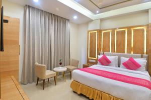 a bedroom with a large bed and a table and chairs at Hotel Gold Palace - 03 Mins Walk From New Delhi Railway Station in New Delhi