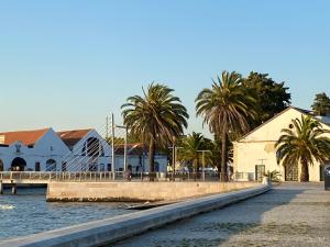 a bridge over a body of water with palm trees at Elegance to close from Lisbon! in Montijo