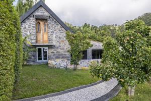 una casa de piedra con árboles delante de ella en Casas Maravilha by Madeira Sun Travel, en Calheta