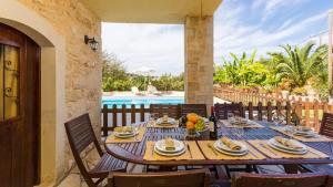 einen Holztisch mit Tellern aus Essen auf einer Terrasse in der Unterkunft Villa Satra in Elefterna