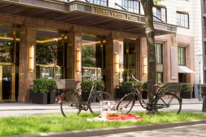 dos bicicletas estacionadas frente a un edificio en Hilton Vienna Plaza en Viena