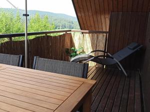 einen Holztisch und Stühle auf einer Terrasse in der Unterkunft Wohnung mit Spielplatz, Kaninchen und Whirlpool in Grafenhausen