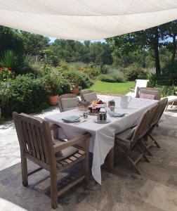 une table avec un tissu de table blanc sur une terrasse dans l'établissement Lou Pantai, Bed and Breakfast, Delux Bedroom, à Aix-en-Provence