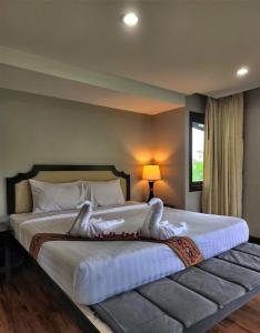 um quarto com uma cama grande com dois cisnes em Hua Hin Home Hill em Hua Hin