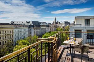 a balcony with a table and chairs and a view of the city at Hilton Vienna Plaza in Vienna