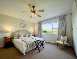 a bedroom with a bed with a ceiling fan and a window at Sundune Guest House in Colchester
