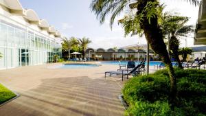 un complejo con una piscina con sillas y una palmera en Hotel Senac Ilha do Boi, en Vitória