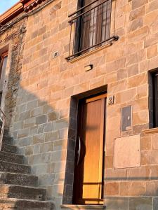 un edificio de ladrillo con una puerta al lado de unas escaleras en Vianova, en Pietrapertosa