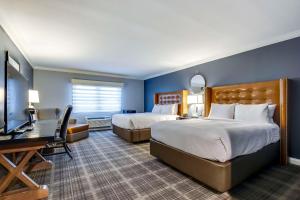 um quarto de hotel com duas camas e uma secretária em The Campbell House Lexington, Curio Collection by Hilton em Lexington
