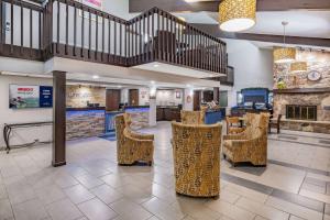 a lobby of a hospital with chairs and a fireplace at AmericInn by Wyndham Plover Stevens Point in Plover