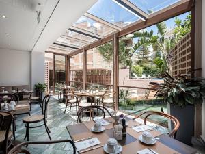 a restaurant with tables and chairs and a large window at Civitel Akali Hotel in Chania