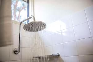a shower with a shower head in a bathroom at Nightcap at High Flyer Hotel in Bankstown