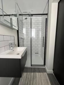 a bathroom with a sink and a glass shower at Studio apartment in Harefield in Harefield