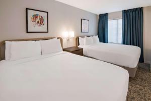 アンドーバーにあるSonesta ES Suites Andover Bostonのベッド2台と窓が備わるホテルルームです。