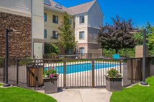 a house with a fence and a swimming pool at Sonesta ES Suites Andover Boston in Andover