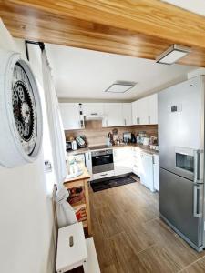 a kitchen with white cabinets and a stainless steel refrigerator at Bohemian Paradise near Prague with Wellness in Řehenice