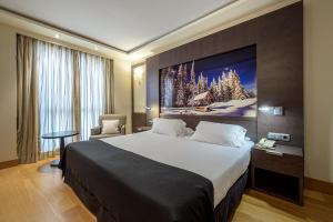 a hotel room with a large bed and a tv on the wall at Hotel Nelva in Murcia