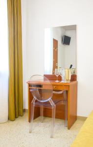 escritorio con silla de cristal junto a una mesa de madera en Hotel Adriatico en Venecia