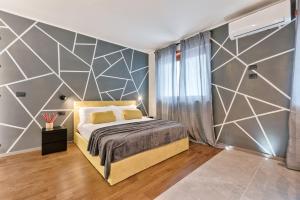 een slaapkamer met een bed met een geometrische accentwand bij Casa RIGOLA by Apartments To Art in Venaria Reale