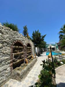 a stone wall with an outdoor oven next to a pool at Baku, Shagan Villa in Baku