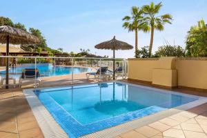 - une piscine dans un complexe avec des palmiers dans l'établissement Wyndham Residences Costa Adeje, à Adeje