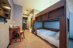 - une chambre avec des lits superposés et un bureau dans l'établissement Residence Hotel Stripe Sapporo, à Sapporo