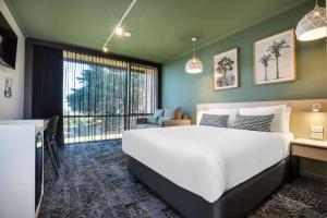 a bedroom with a large bed and a large window at Nightcap at Morwell Hotel in Morwell
