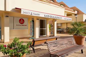 a building with a bench in front of a store at Wyndham Residences Costa Adeje in Adeje