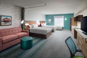 a hotel room with two beds and a couch at Home2 Suites By Hilton Towson in Towson