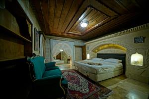 a bedroom with a bed and a couch and a chair at Holiday Cave Hotel in Göreme