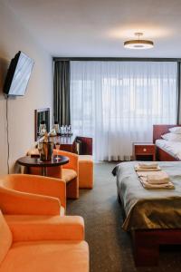 Habitación de hotel con muebles de color naranja y cama en Willa Plażowa, en Międzyzdroje
