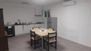 a kitchen with a wooden table and chairs in it at Apartman i Sobe Vasilić in Jurandvor