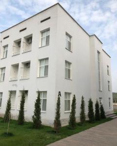 a white building with trees in front of it at Keles Arasan SPA Hotel in Kökterek