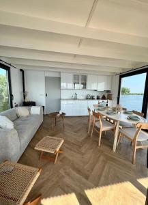 a living room with a couch and a table at Surla houseboat "Nevel" Kagerplassen with tender in Buitenkaag