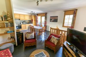 eine Küche und ein Wohnzimmer mit einem Tisch und Stühlen in der Unterkunft Le Col Roulé in Valloire